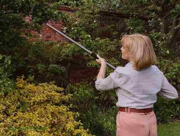 Woman using a Kent & Stowe Long Reach Easy Pruner 1.3m